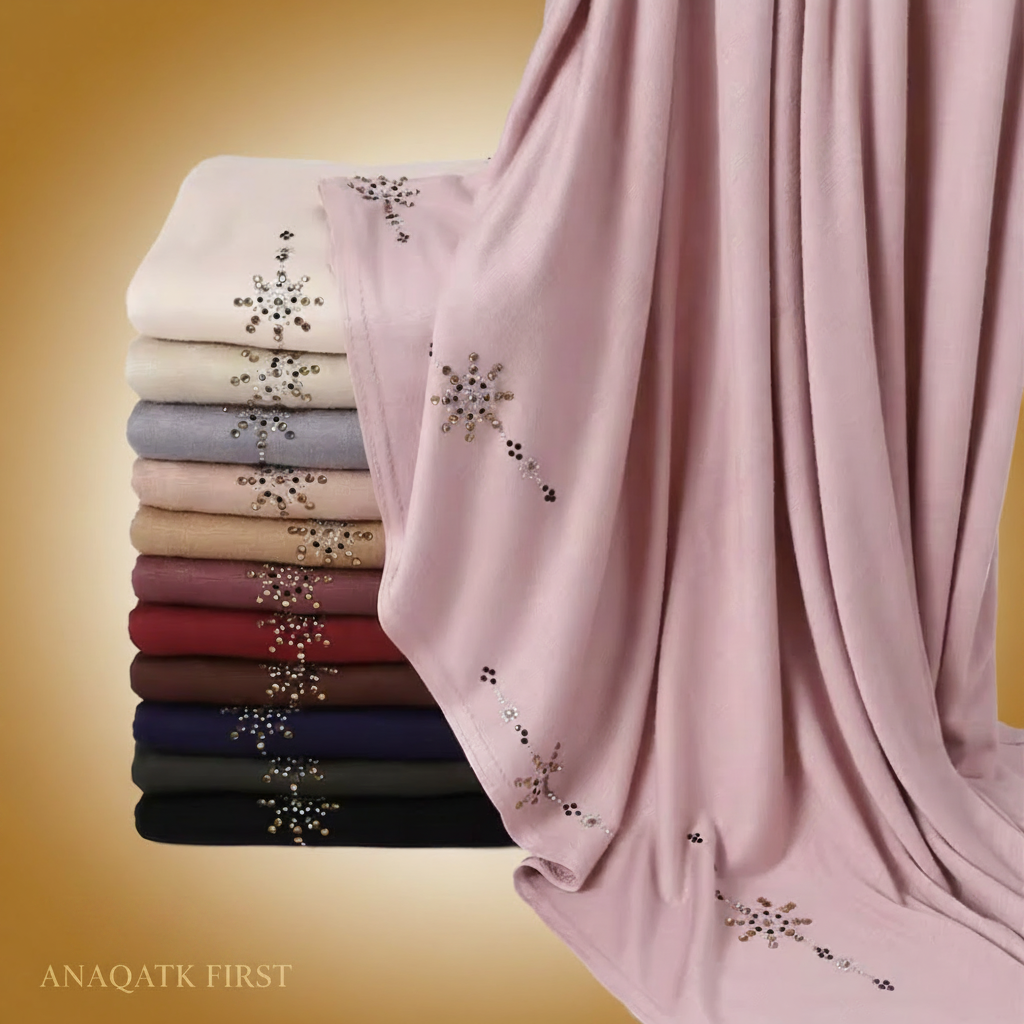 Stack of folded scarves with embroidered designs in various colors on a white background