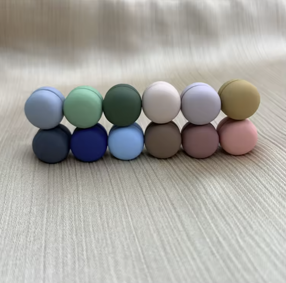 Row of colorful round objects on a textured surface