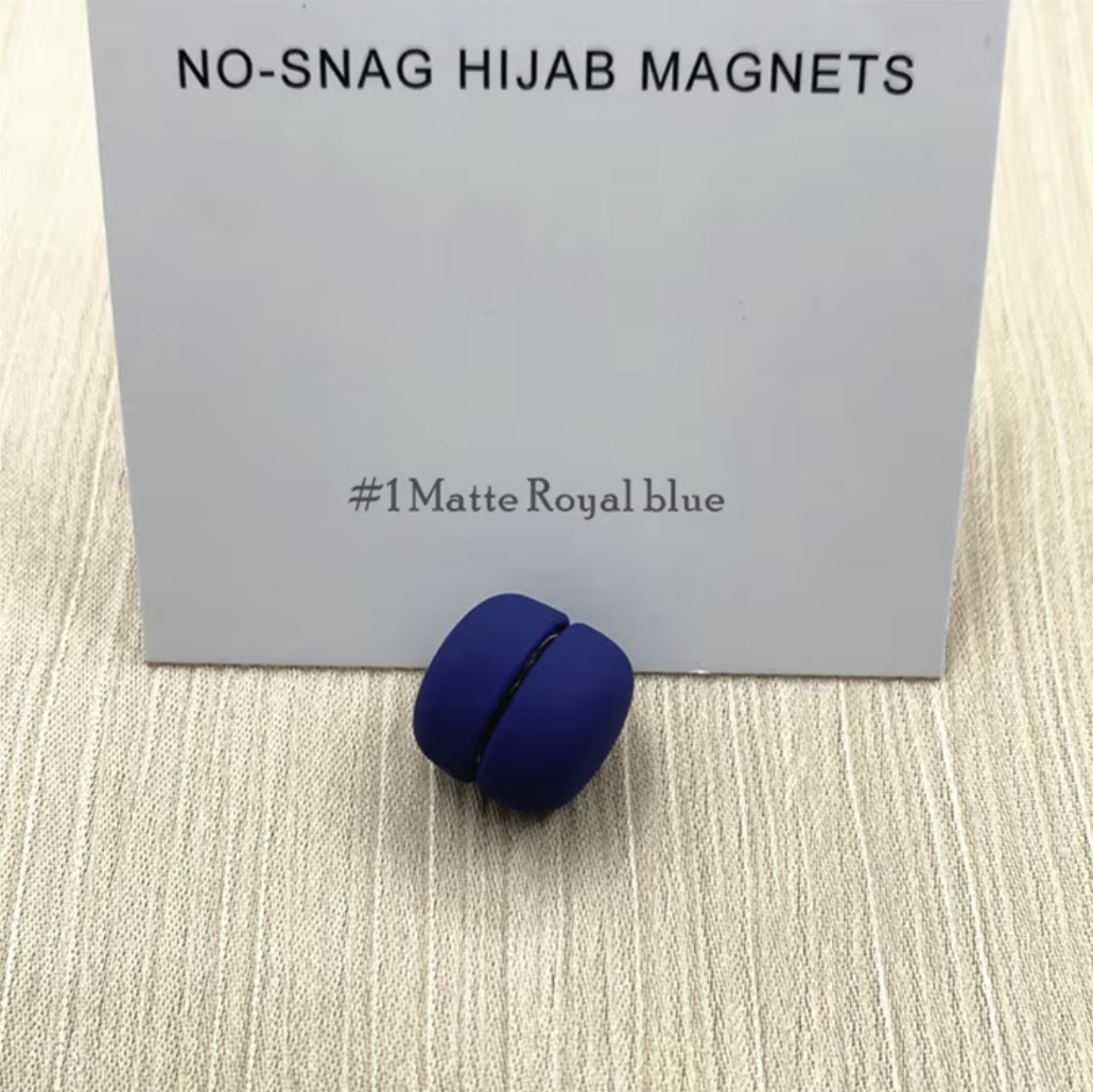 Blue hijab magnet on a beige surface with a gray card in the background