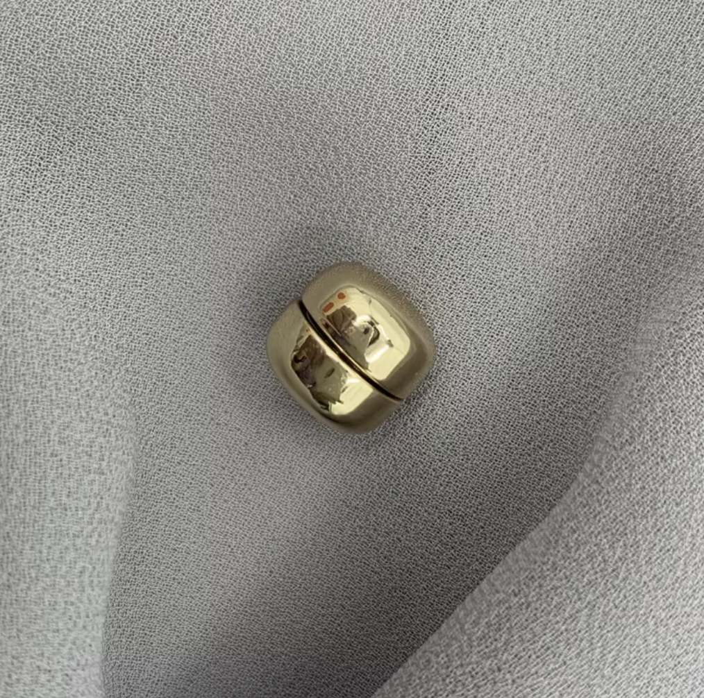 Gold metallic object on a textured gray surface