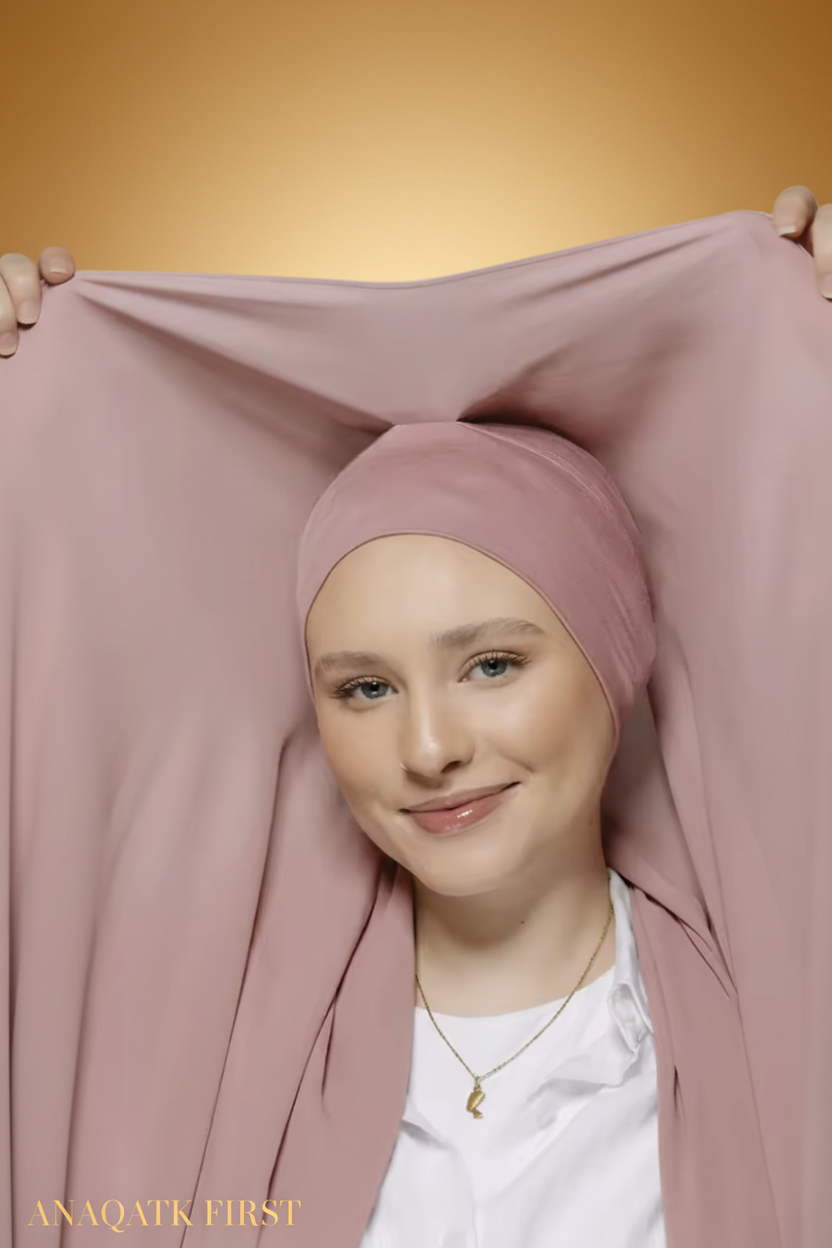 Woman wearing a pink hijab with a plain background