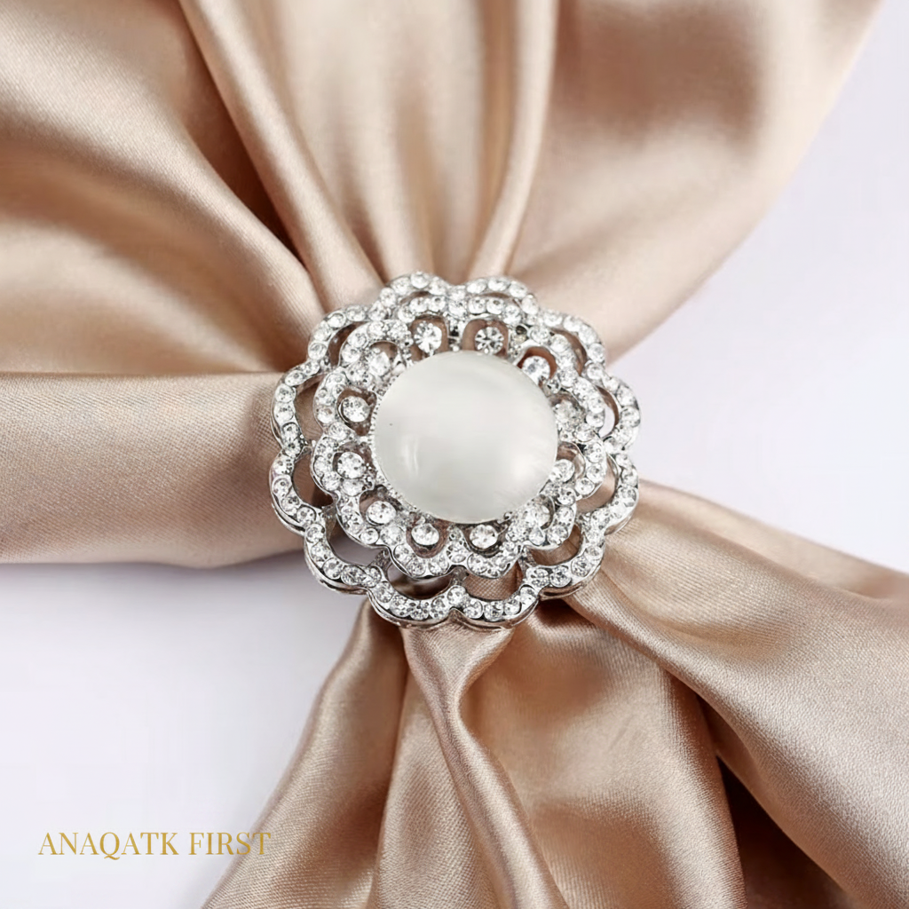 Decorative brooch with pearl center on a beige satin ribbon