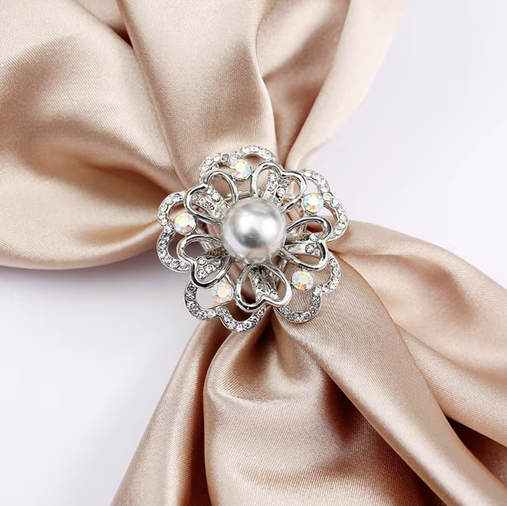 Decorative brooch with pearl center on a beige satin fabric