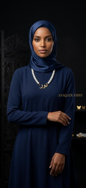 Woman wearing a blue hijab and dress with jewelry against a dark background